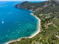 Baia con acque cristalline e numerose barche. Ville immerse nel verde e sentieri panoramici: ecco cosa vedere all'Argentario per una vacanza indimenticabile.