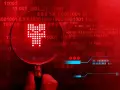 Pod lupą widać symbol przypominający czaszkę, symbolizujący **malware**. Tło to czerwony kod binarny, sugerujący zagrożenie cyfrowe.