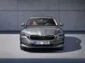 Nowa Skoda Octavia w szarym kolorze, z brązowym wnętrzem, prezentuje się elegancko na tle betonowej ściany.
