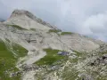Rifugio alpino con escursionisti e gregge in un paesaggio montano mozzafiato, vicino a Passo Val Gardena.