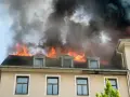 Dachstuhlbrand mit Flammen und schwarzem Rauch. Ein trauriger Nachweis, warum eine Hausratversicherung wichtig ist.