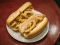 Dos bocadillos de calamares fritos en pan blanco sobre un plato blanco.