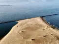 Piaskowy cypel i falochrony wyznaczają, gdzie jest ujście Wisły do Bałtyku.