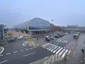 Dworzec Poznań Główny, z nowoczesną architekturą i parkingiem pełnym samochodów, gotowy na podróżnych do Nowego Tomyśla.