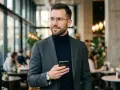 Elegancki mężczyzna z telefonem, zastanawia się nad typami osobowości tinder.