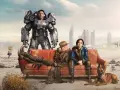 Personajes de Fallout 4 en un sofá desértico. Un soldado en armadura, un hombre con sombrero y una mujer con uniforme azul, junto a un perro. El amor en el páramo, un posible fallout 4 romance.