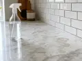 Une bouteille de vinaigre blanc sur un comptoir en pierre naturelle, prêt à nettoyer les taches.