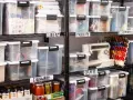 Organized basement storage ideas with labeled clear bins for linens, holiday items, crafts, electronics, and dishware.