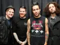 Czterech mężczyzn z zespołu Fall Out Boy pozuje do zdjęcia na tle czarnej kurtyny.