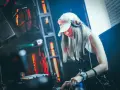 DJane legt auf, die Menge tanzt zu fetter electro dance music. Rote Lichter blitzen, die Musik pulsiert.