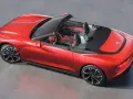 Czerwony MG Roadster z otwartym dachem, sportowe wnętrze, nowoczesne felgi i aerodynamiczne linie.