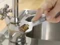 Hand repariert tropfenden wasserhahn mit einem Schraubenschlüssel.