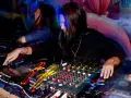 DJka miksuje energetyczne rytmy afro house w klubowej atmosferze. Kolorowe światła i dynamiczna muzyka tworzą niepowtarzalny klimat.