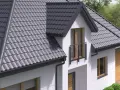 Nowoczesny dom z szarym dachem z dachówki, z dwoma oknami dachowymi i małym balkonem. Widać też lukarnę.