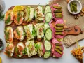 Eleganckie kanapki na przyjęcie: z łososiem, serem i gruszką, salami i ogórkiem. Idealne na każdą okazję.