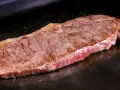 Filete de ternera jugoso cocinándose en una plancha. Perfecto para tus recetas con filetes de ternera.