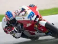 Piloto en plena curva durante una carrera de moto gp. La moto roja y blanca lleva el número 79.