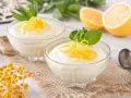 Dos copas de cremoso mousse de limón con leche condensada, decoradas con ralladura de limón y menta.