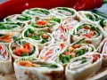 Szybkie przekąski z tortilli na zimno: rolki z łososiem, rukolą i papryką. Idealne na imprezę lub jako lekki lunch.