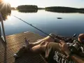Spokojny dzień nad jeziorem Urszulewskim. Wędkarz czeka na branie, słońce zachodzi, odbijając się w spokojnej tafli wody.