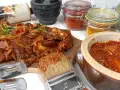 Karkówka na grilla w aromatycznej marynacie, gotowa do pieczenia. Obok pędzel z marynatą i słoiczki z przyprawami.