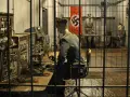 Wnętrze mamerki bunkrów z manekinami żołnierzy i niemiecką flagą. Na pierwszym planie manekin przy konsoli, w tle dwaj żołnierze.