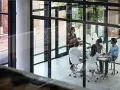 A team discusses network infrastructure solutions in a modern office meeting room.
