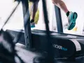 Gambe che corrono sul tapis roulant, un allenamento intenso dove correre sul tapis roulant è più facile.