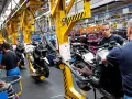 Männer arbeiten an Motorrädern in einer Fabrik. An Christi Himmelfahrt muss man anscheinend arbeiten.
