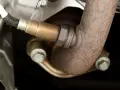 Sensore lambda aria avvitato al tubo di scarico arrugginito.