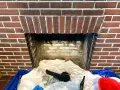Camino in mattoni pronto per la pulizia. Il braciere è vuoto, ma c'è un allarme per la stufa a pellet.