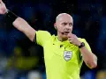 Sędzia piłkarski w żółtej koszulce z naszywką UEFA, dmucha w gwizdek. Zastanawiasz się, ile zarabia sędzia piłkarski?