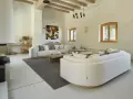 Salón moderno con sofás blancos, chimenea y suelo de microcemento sobre azulejos.