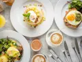 Ein köstlicher Brunch in Berlin: Pancakes mit Früchten, Eggs Benedict und Croque Madame mit Spiegelei. Dazu Kaffee und Saft.