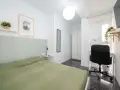 Habitación luminosa con cama, escritorio y armario. Ideal como piso para estudiantes, con decoración moderna y plantas.