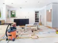 Chantier d'un appartement en rénovation : armoires sombres, structure en bois, aspirateur, outils. Idéal pour des conseils rénovation appartement.