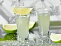 Dwa kieliszki z drinkiem, ozdobione solą i ćwiartkami limonki. Idealne na letnie wieczory, jak z przepisu na "Wściekły pies".