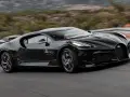 Czarny Bugatti La Voiture Noire pędzi po krętej drodze. Zastanawiasz się, ile kosztuje ten cud motoryzacji?