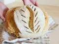 Pane fatto in casa, fragrante e dorato, con tagli che ricordano la ricetta della nonna.