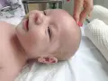 Delikatne dotknięcie palcem na główce niemowlaka, gdzie znajduje się ciemiączko.