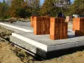 Budowa domu: betonowy fundament, bloczki, palety cegieł. Zastanawiasz się, ile kosztują fundamenty? Oto początek inwestycji.