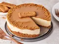 Ein cremiger Lotus Cheesecake mit Karamellglasur und Keksbröseln, dekoriert mit einem Lotus-Keks.