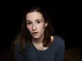 Portret Anny Paligi z ciemnymi włosami i w szarej bluzce, patrzącej wprost przed siebie.