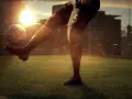 Jugador de fútbol con el número 5 en su pantalón corto, pateando un balón en un campo al atardecer. El sol brilla intensamente detrás de los edificios de la ciudad. ufl pc.