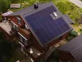Dom z panelami fotowoltaicznymi na dachu. To rozwiązanie, co to fotowoltaika, pozwala na produkcję własnej energii elektrycznej ze słońca.