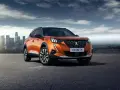 Pomarańczowy Peugeot 2008 na tle miasta. Sprawdź jego wymiary i możliwości.