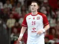Wiktor Jankowski, numer 24, w białej koszulce z czerwonymi rękawami, z orłem na piersi, na tle trybun.