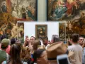 Mona Lisa i Louvren, omgiven av besökare som fotograferar. Hur lång tid tog det att måla Mona Lisa? En evighet av konstnärlig genialitet.