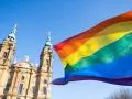 Regenbogenfahne weht vor evangelischer Kirche. Ein Zeichen für Akzeptanz und Vielfalt, das die Botschaft der evangelischen Kirche LGBT widerspiegelt.