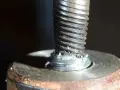 Uszkodzona śruba w aluminiowej obudowie. Widoczne ślady po próbie wykręcenia urwanej śruby z aluminium.
